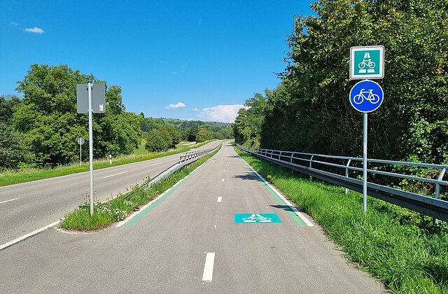 Ein zweispuriger Radschnellweg verläuft neben einer Straße