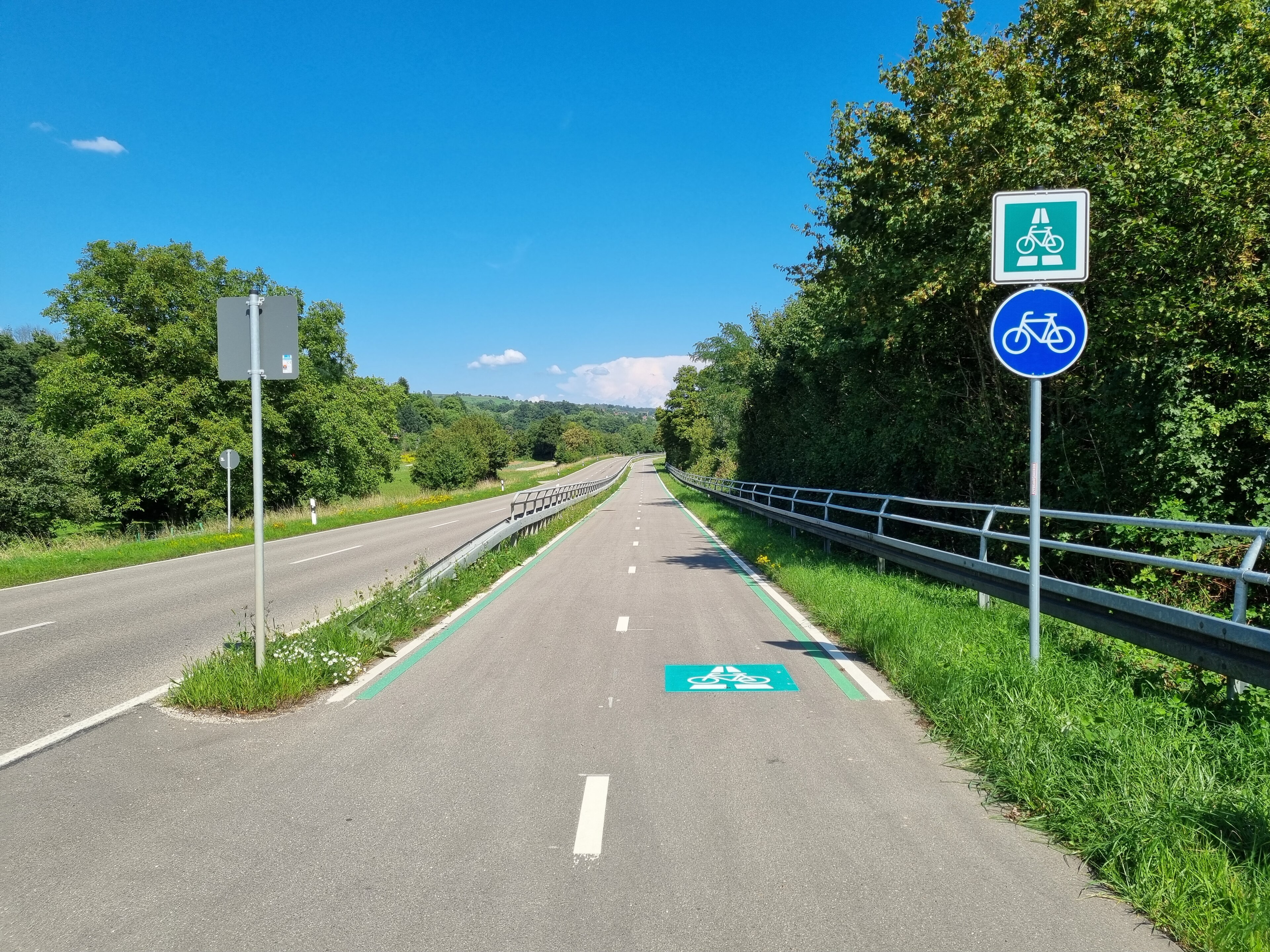 Ein zweispuriger Radschnellweg verläuft neben einer Straße